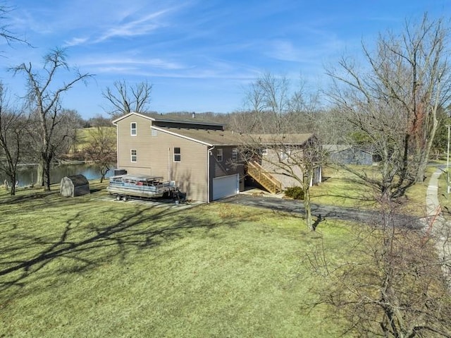 view of side of property featuring a yard, a garage, and driveway