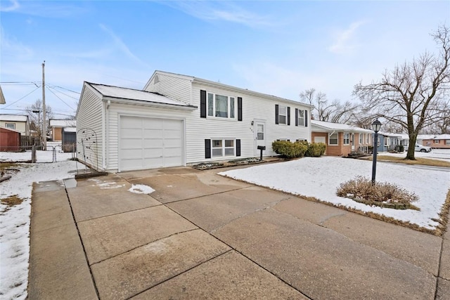 view of front of house with concrete driveway, fence, and a garage