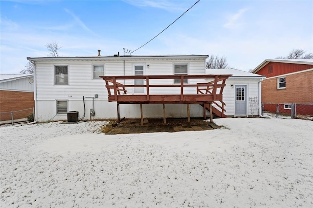 snow covered rear of property with stairway, a deck, and fence