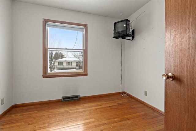 unfurnished room with visible vents, light wood-style flooring, and baseboards