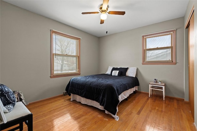 bedroom with baseboards, ceiling fan, and light wood finished floors