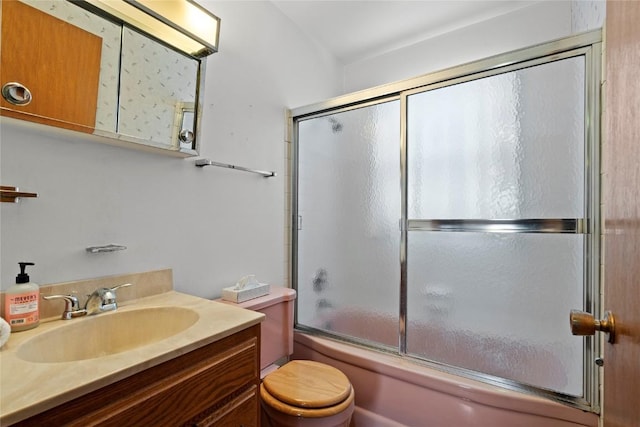 full bath featuring toilet, vanity, and bath / shower combo with glass door