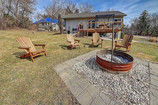 exterior space with stairway, a fire pit, and a deck