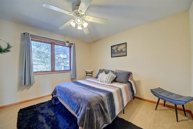 carpeted bedroom with baseboards, a textured ceiling, and ceiling fan