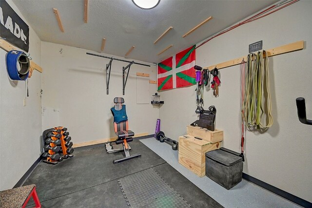 exercise area with baseboards and a textured ceiling