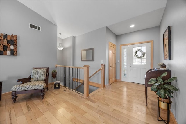 foyer entrance featuring baseboards, visible vents, and light wood-type flooring