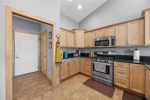 kitchen featuring light brown cabinets, appliances with stainless steel finishes, and high vaulted ceiling