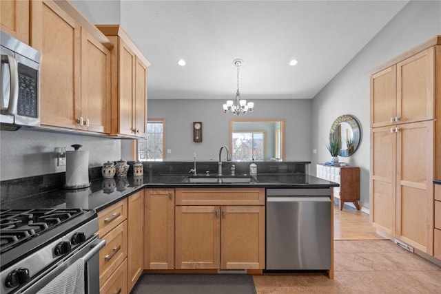 kitchen with light brown cabinetry, a peninsula, a notable chandelier, stainless steel appliances, and a sink