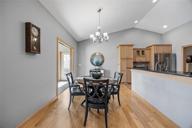 dining space with vaulted ceiling, a notable chandelier, recessed lighting, and light wood finished floors