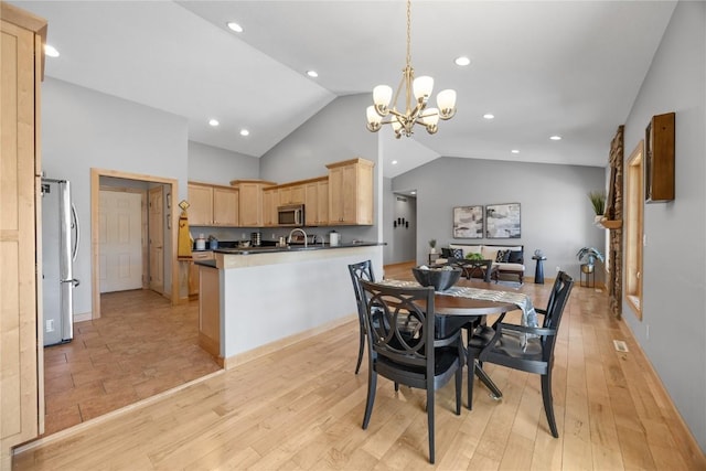 dining room with an inviting chandelier, light wood-style flooring, recessed lighting, and high vaulted ceiling