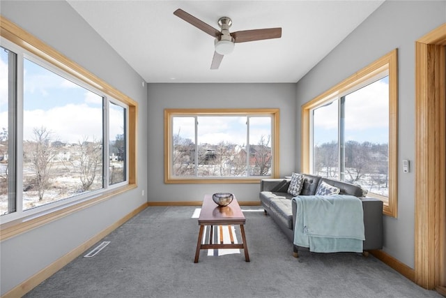 carpeted living area featuring visible vents, a healthy amount of sunlight, and baseboards