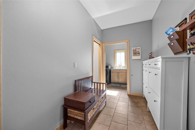 interior space with light tile patterned floors, baseboards, and a sink