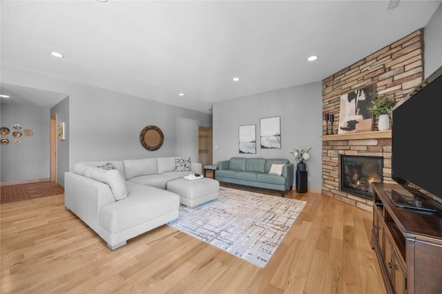 living area featuring recessed lighting, light wood-style flooring, and a fireplace