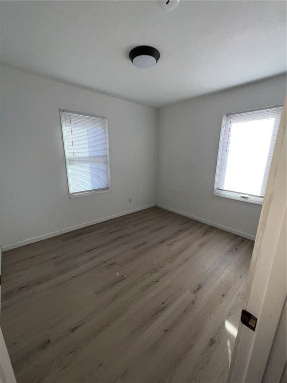 empty room with baseboards and wood finished floors