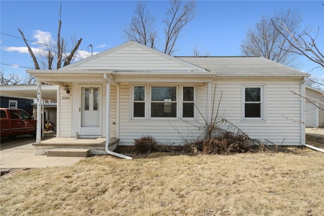 view of front of home featuring a carport, covered porch, driveway, and a shingled roof