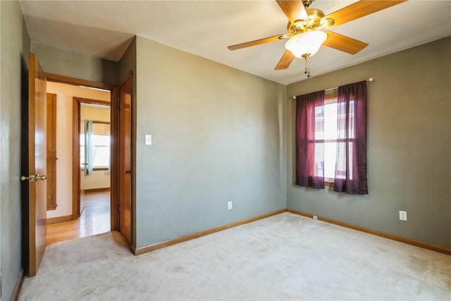 empty room featuring baseboards, light carpet, and a healthy amount of sunlight