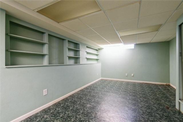 finished below grade area featuring baseboards and a drop ceiling