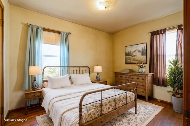 bedroom with wood finished floors and baseboards