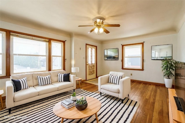 living room with light wood-type flooring, baseboards, and ceiling fan