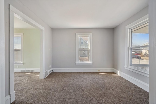 carpeted empty room with baseboards and visible vents