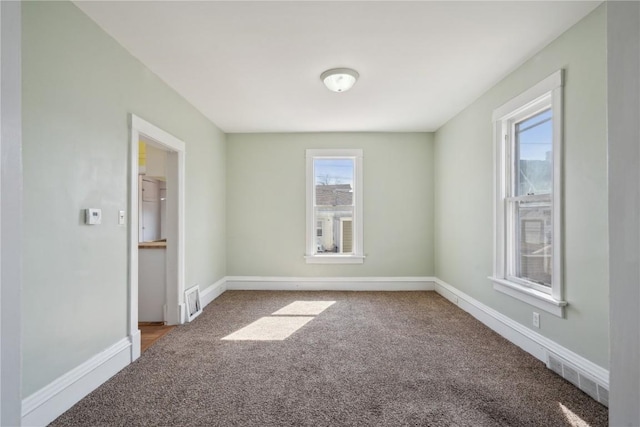 carpeted empty room featuring visible vents and baseboards