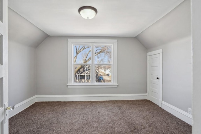 additional living space featuring baseboards, lofted ceiling, and carpet flooring