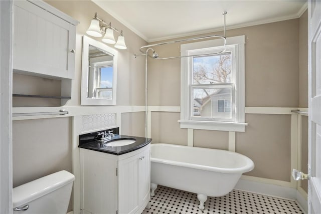 bathroom featuring plenty of natural light, toilet, a freestanding bath, and vanity