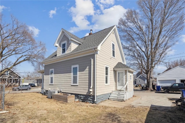 view of property exterior featuring entry steps, cooling unit, and roof with shingles