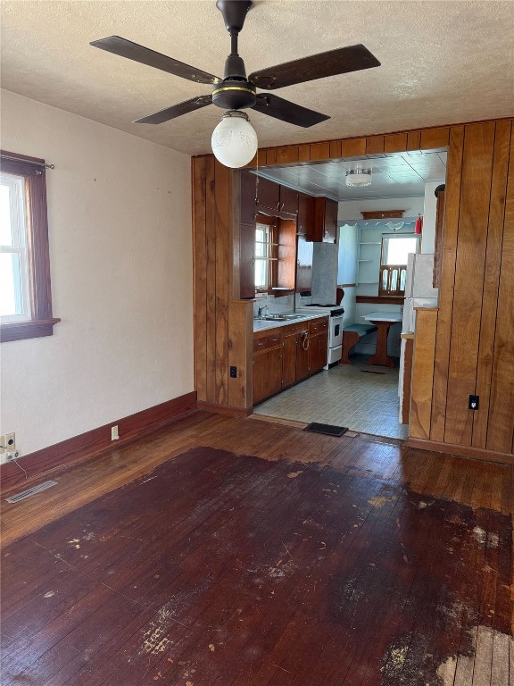 kitchen with visible vents, brown cabinets, electric stove, hardwood / wood-style flooring, and a textured ceiling