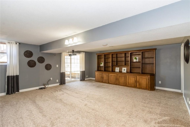 unfurnished living room featuring baseboards, light carpet, and a healthy amount of sunlight