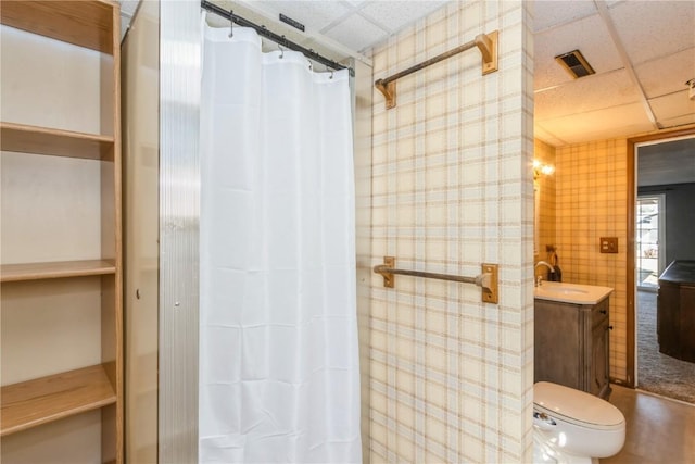 bathroom with visible vents, toilet, a drop ceiling, a shower with shower curtain, and vanity