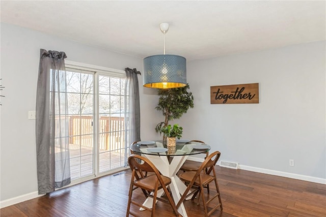 dining area with wood finished floors, visible vents, and baseboards