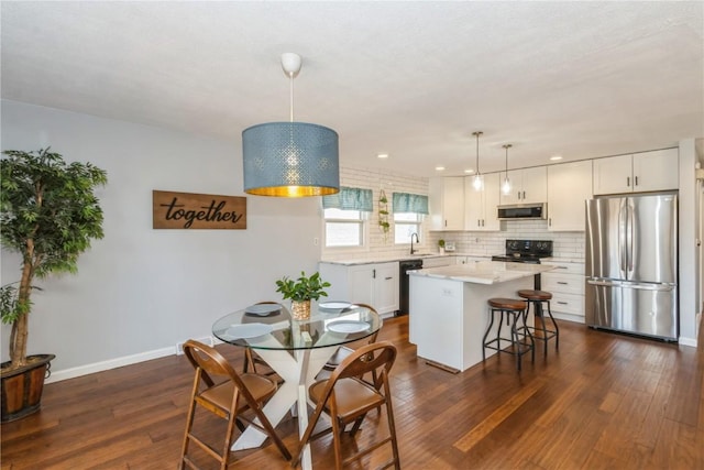 dining space with recessed lighting, baseboards, and dark wood-style flooring