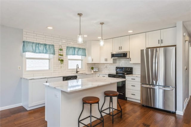 kitchen with black appliances, a sink, a kitchen island, backsplash, and dark wood-style floors