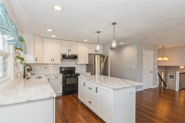 kitchen featuring a sink, a kitchen island, dark wood finished floors, stainless steel appliances, and decorative backsplash