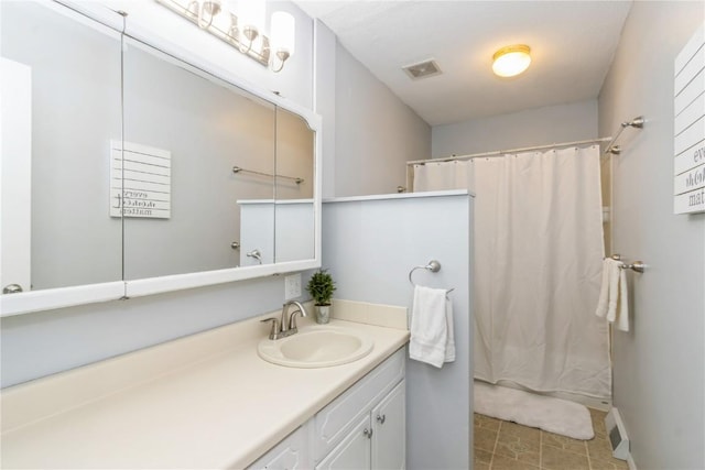 bathroom with tile patterned floors, visible vents, curtained shower, and vanity