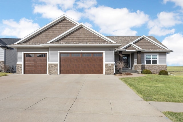 craftsman inspired home with stone siding, a front lawn, an attached garage, and driveway