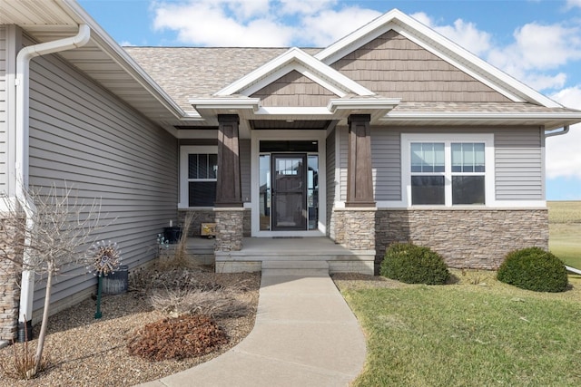 property entrance with stone siding and a shingled roof