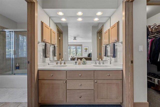 bathroom featuring double vanity, ensuite bath, a ceiling fan, and a sink