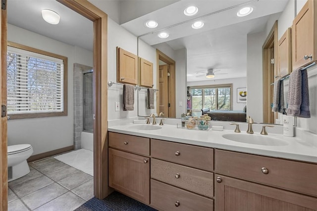 ensuite bathroom featuring double vanity, connected bathroom, tile patterned floors, and a sink