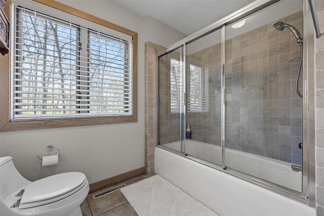 bathroom with baseboards, visible vents, enclosed tub / shower combo, tile patterned flooring, and toilet