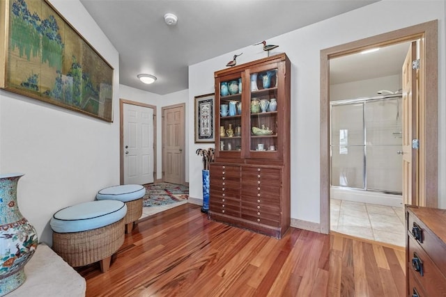 interior space featuring wood finished floors, a stall shower, and baseboards