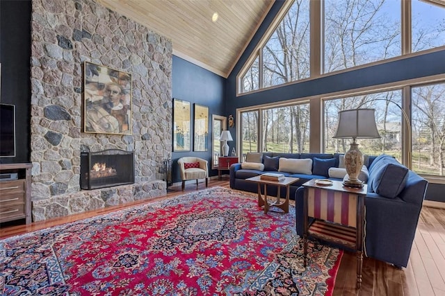 living room with plenty of natural light, a fireplace, wood ceiling, and wood finished floors