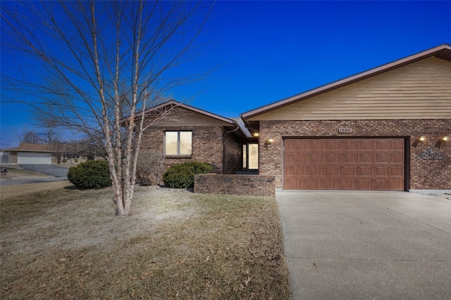 view of front facade featuring brick siding, an attached garage, concrete driveway, and a front yard