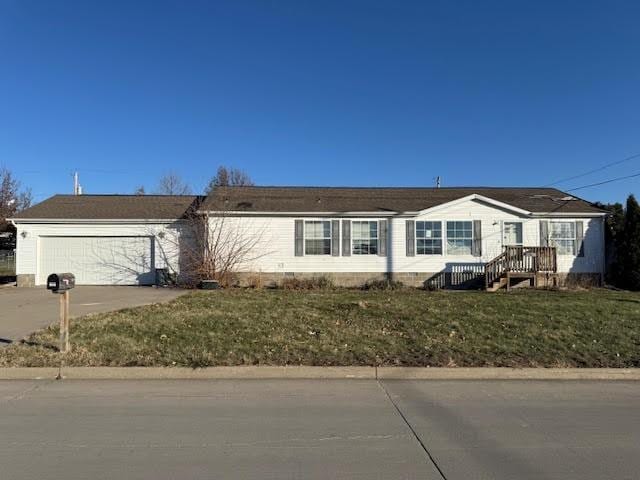 view of front of property featuring a front lawn, concrete driveway, and a garage