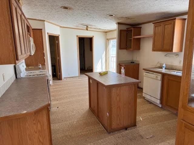 kitchen featuring brown cabinetry, a kitchen island, white dishwasher, a textured ceiling, and crown molding