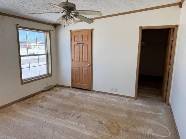 unfurnished bedroom with light colored carpet, a textured ceiling, and ornamental molding