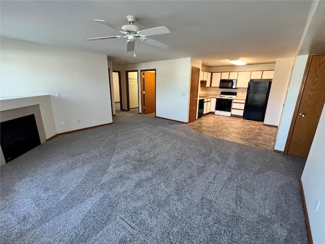 unfurnished living room with carpet flooring, a fireplace, a ceiling fan, and baseboards