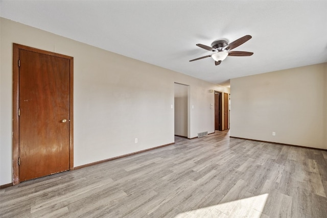 unfurnished room featuring light wood finished floors, visible vents, a ceiling fan, and baseboards