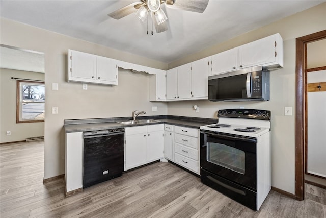 kitchen with dark countertops, stainless steel microwave, dishwasher, electric stove, and a sink